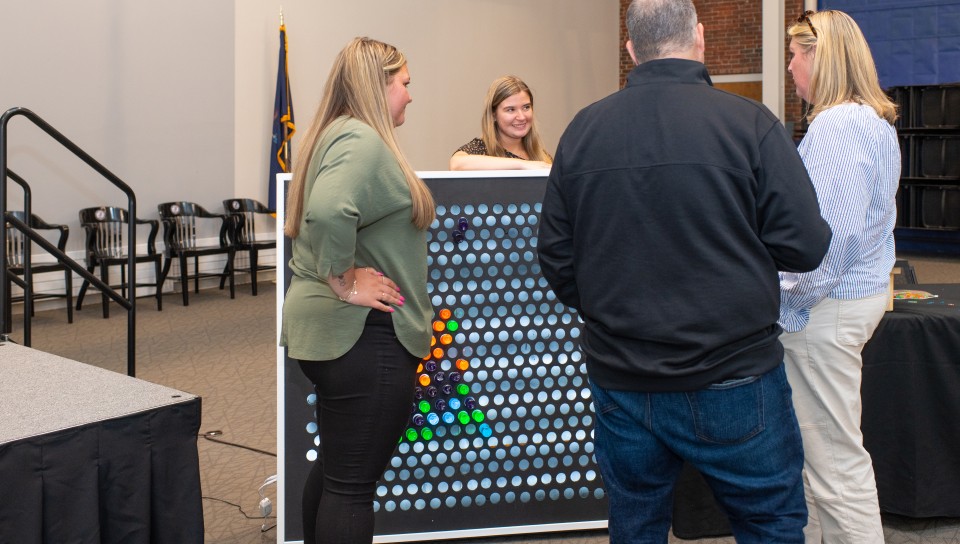 People view a large "Lite Brite" 