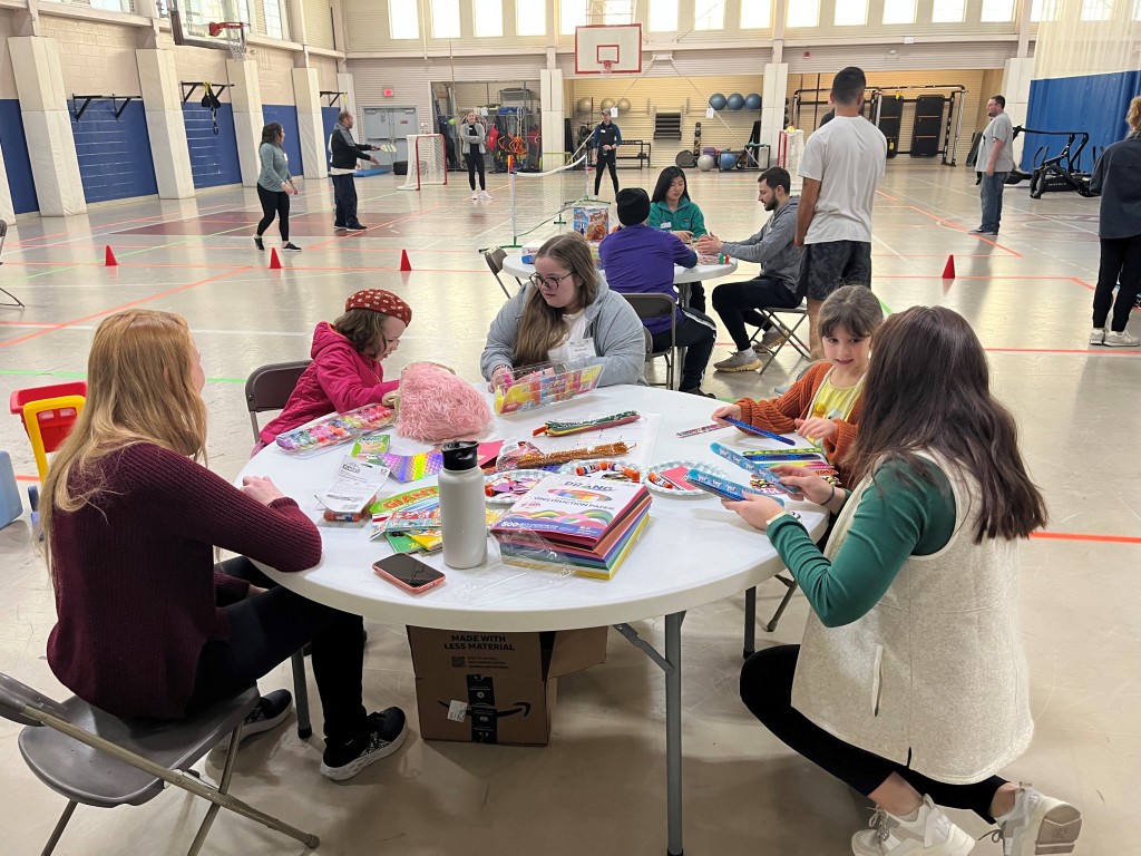 students working on crafts with kids at LEND event