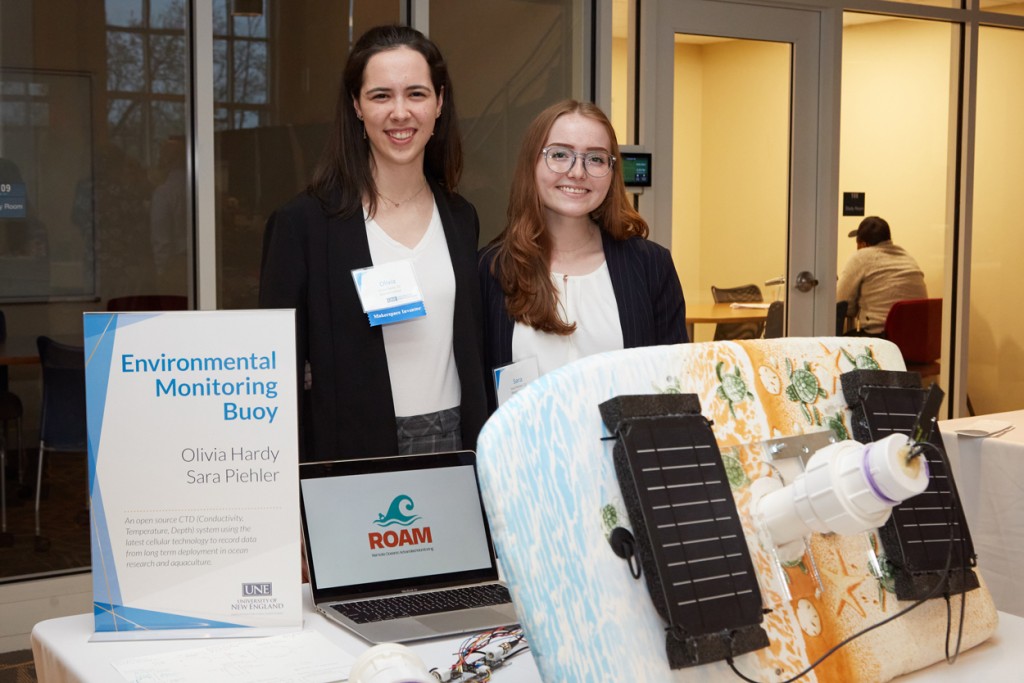 Two students present their environmental monitoring buoy at a Student Innovation Showcase