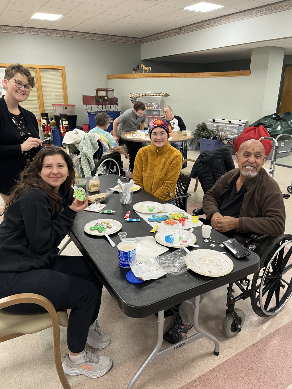A group of students pose with residents of the Barron Center during a holiday cookie decorating event