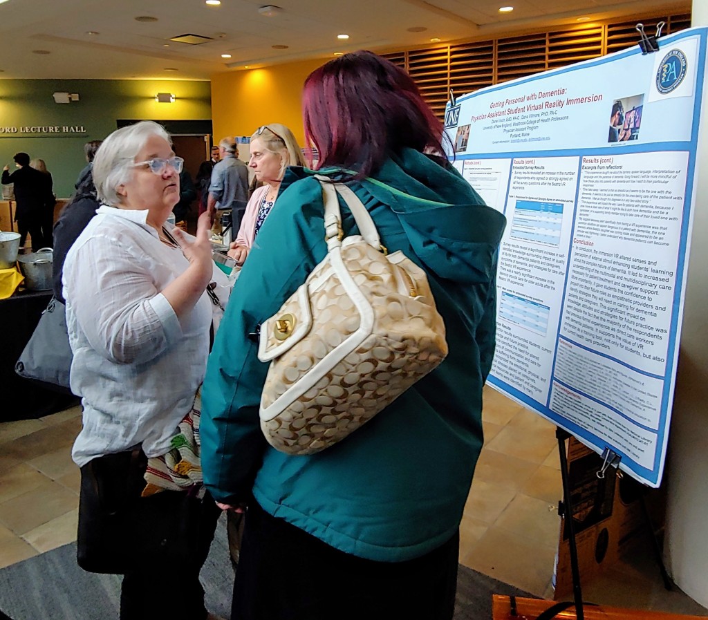 Katherine Rudolph chats with an attendee about the UNE research poster Getting Personal with Dementia