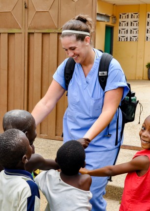 UNE Student with children in Ghana