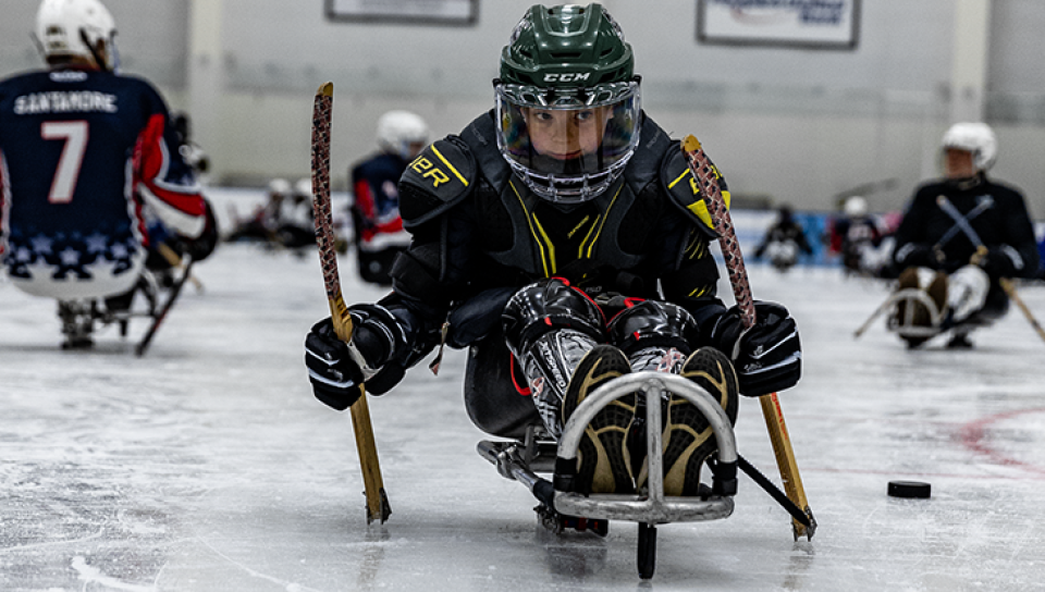 A child uses an adaptive hockey sled 