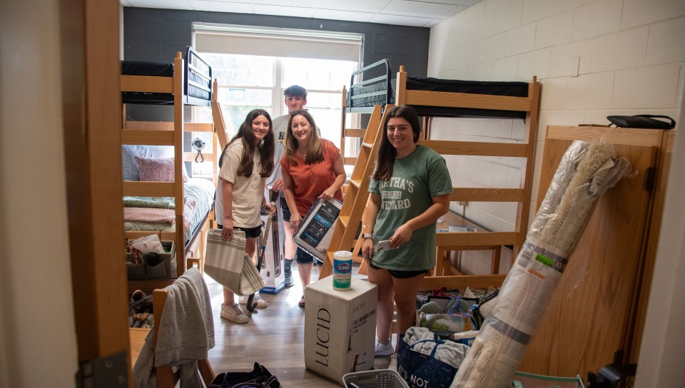 Students move into their dorm rooms with the help of family