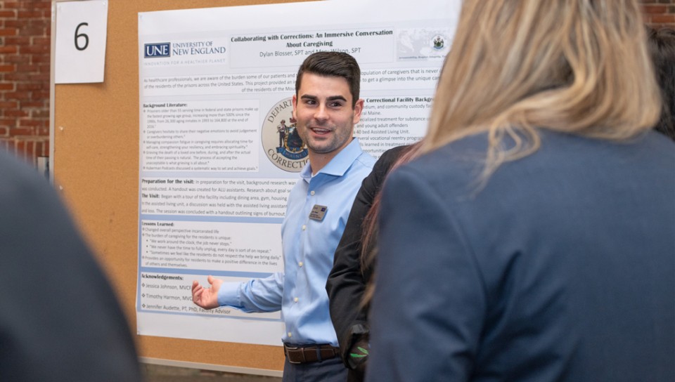 A doctor of physical therapy student presents their research poster at a symposium