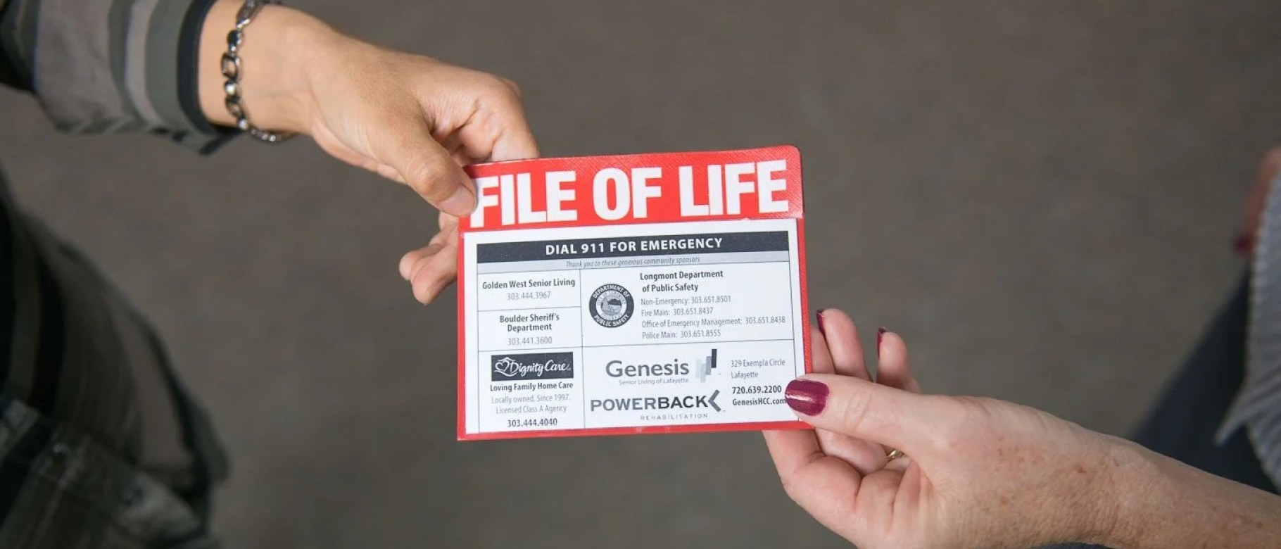 The File of Life pamphlet is shown being handed between two people