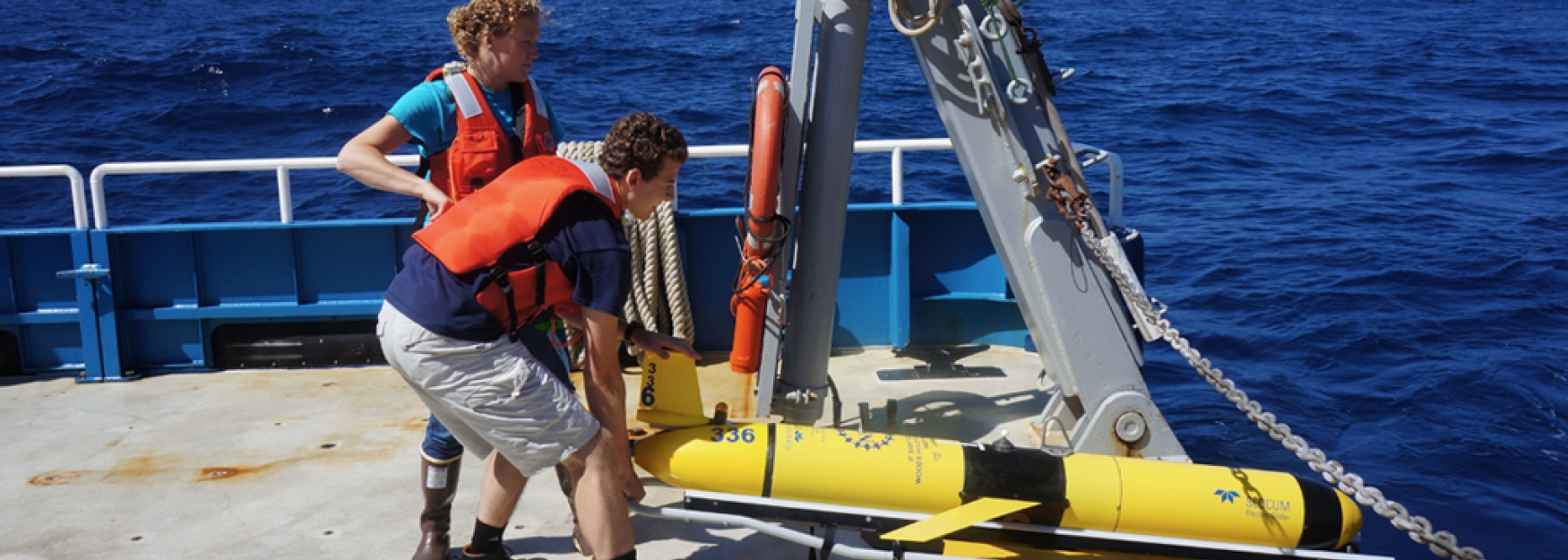 Andy Robinson deploys a research device on a research vessel in the ocean