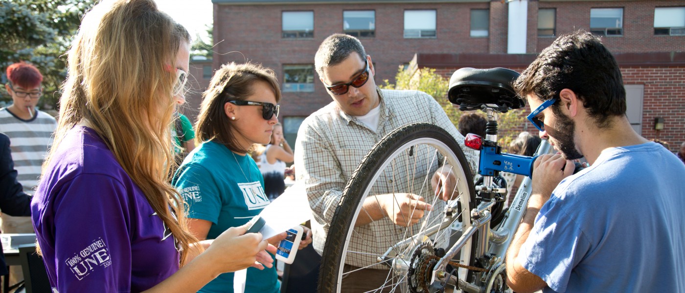 Several U N E students examine a bicycle at the Biddeford Campus Involvement Fair 