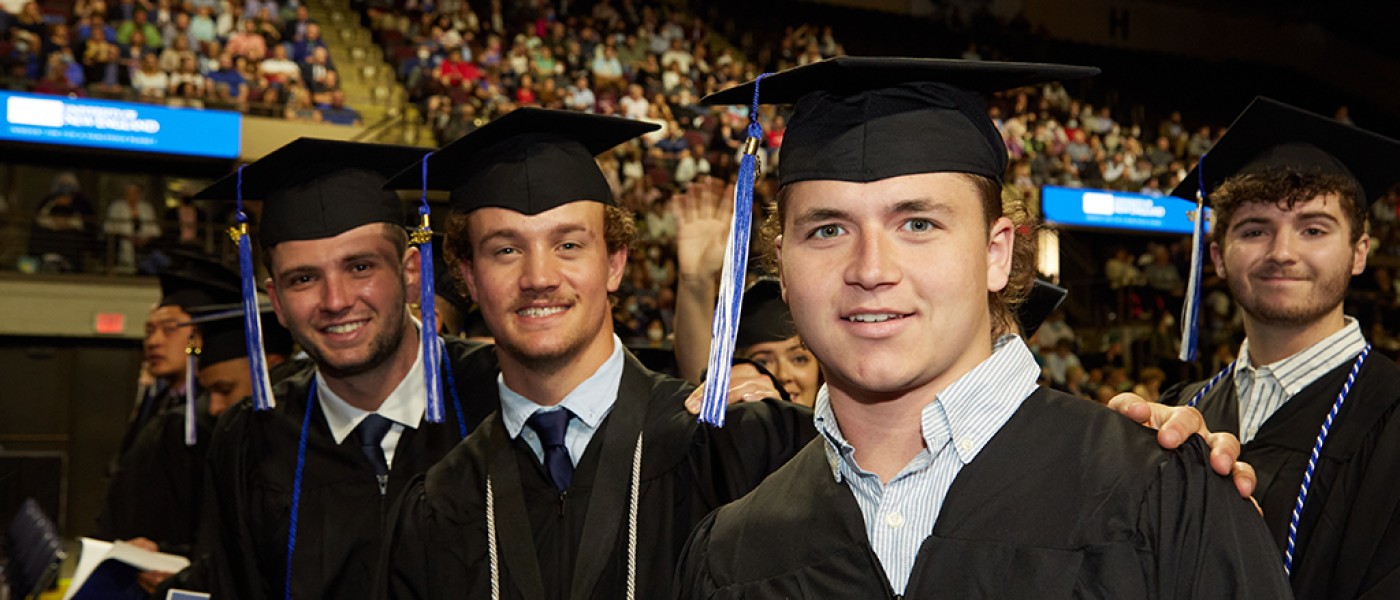 Male graduates smile at the Commencement cermony
