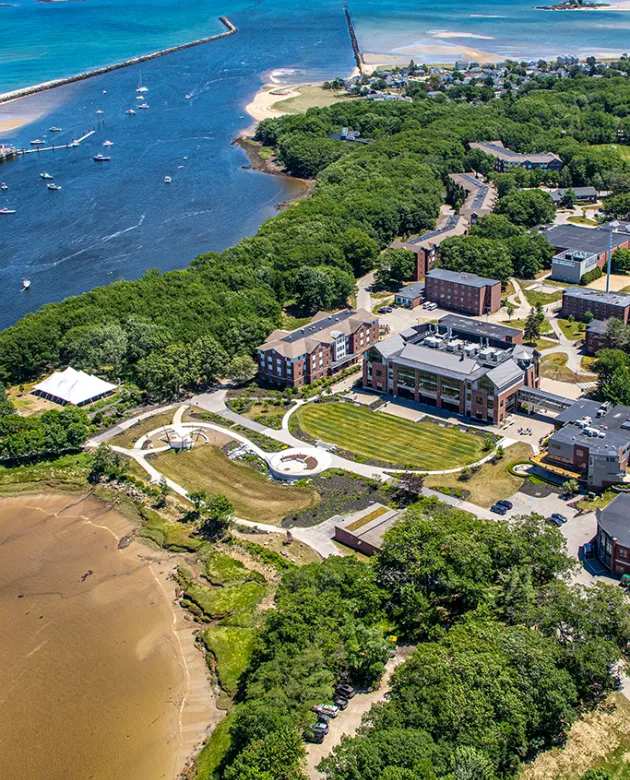 An aerial view of brick buildings by a beach and an ocean