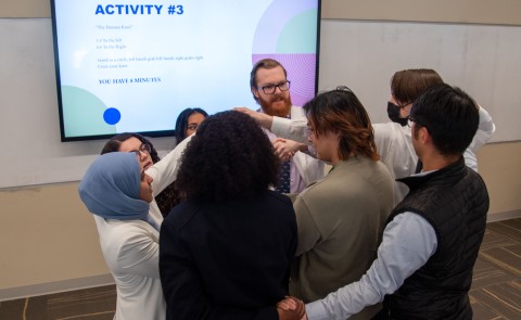 Osteopathic medical students try to unwind a "human knot" as part of a communication exercise