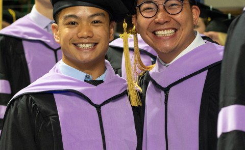 UNE graduates smile for the camera at Commencement