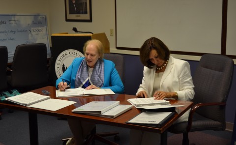President of YCCC Barbara Finkelstein (left) and UNE President Danielle Ripich sign the transfer agreement.