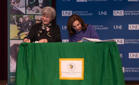 Catherine McAuley's Head of School Kathryn Woodson Barr and UNE President Danielle Ripich officialize the new agreement between 
