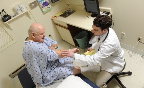 A UNE student treats an elderly patient