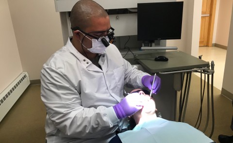Recent UNE graduate C.J. Castonguay performs a procedure on a patient at the Katahdin Valley Health Center