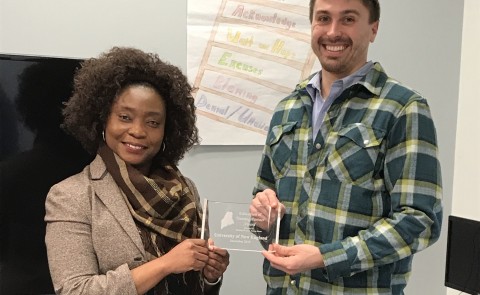FedCap Biddeford Site Manager Sianeh Omeze presents UNE with the Education Partner Award, accepted by Ian Imbert, M.P.H.