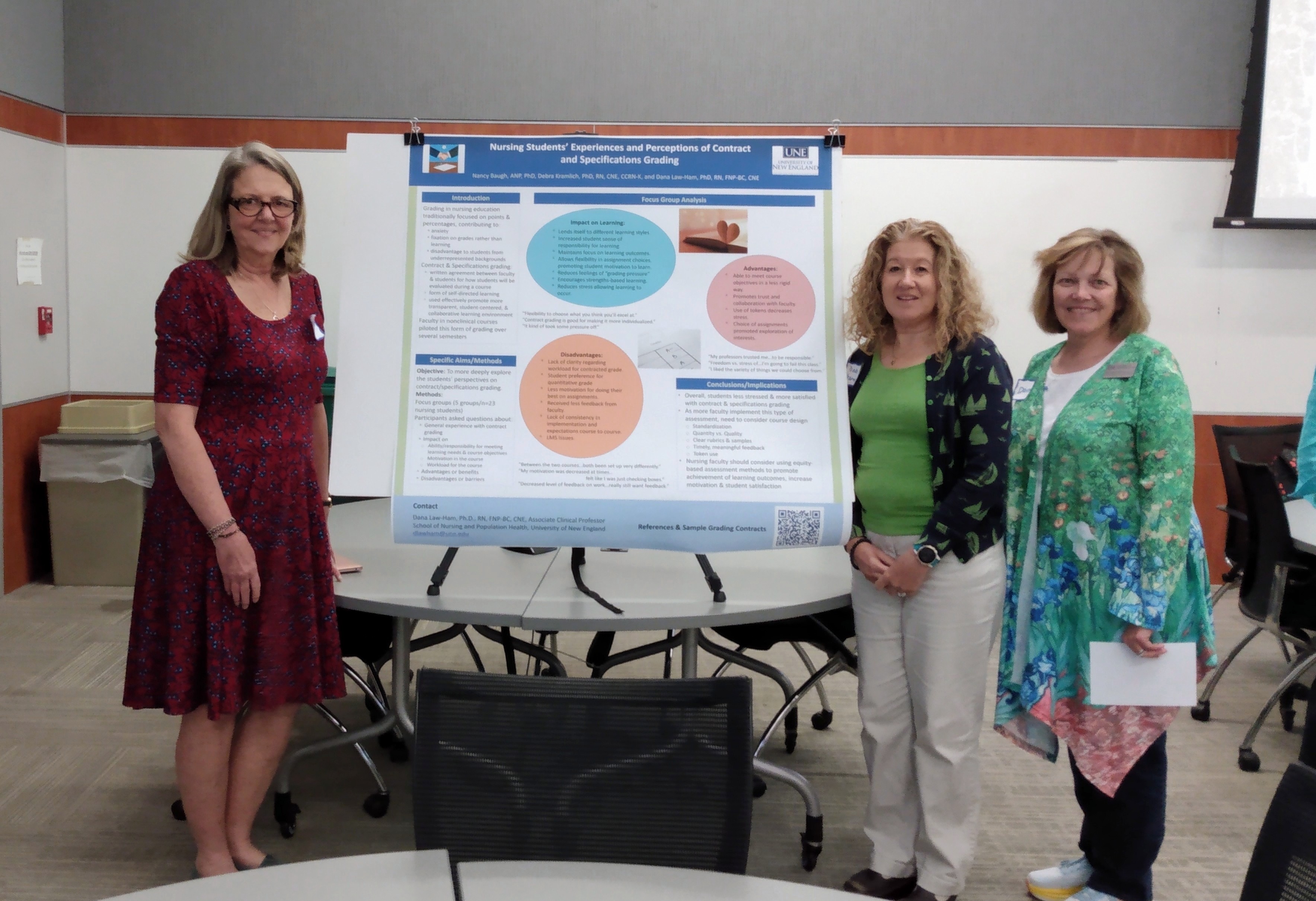 Three UNE faculty members stand next to a research poster