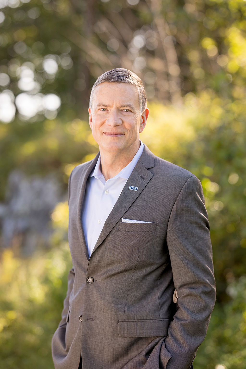 Portrait of U N E President James Herbert standing outside and smiling at the camera