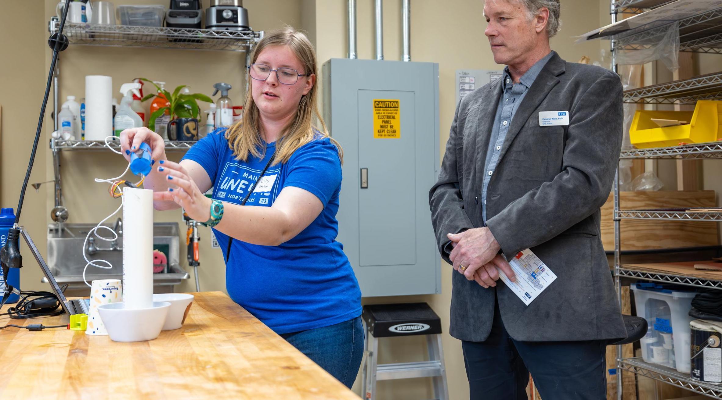 A student displays a marine research device fashioned from PVC pipes