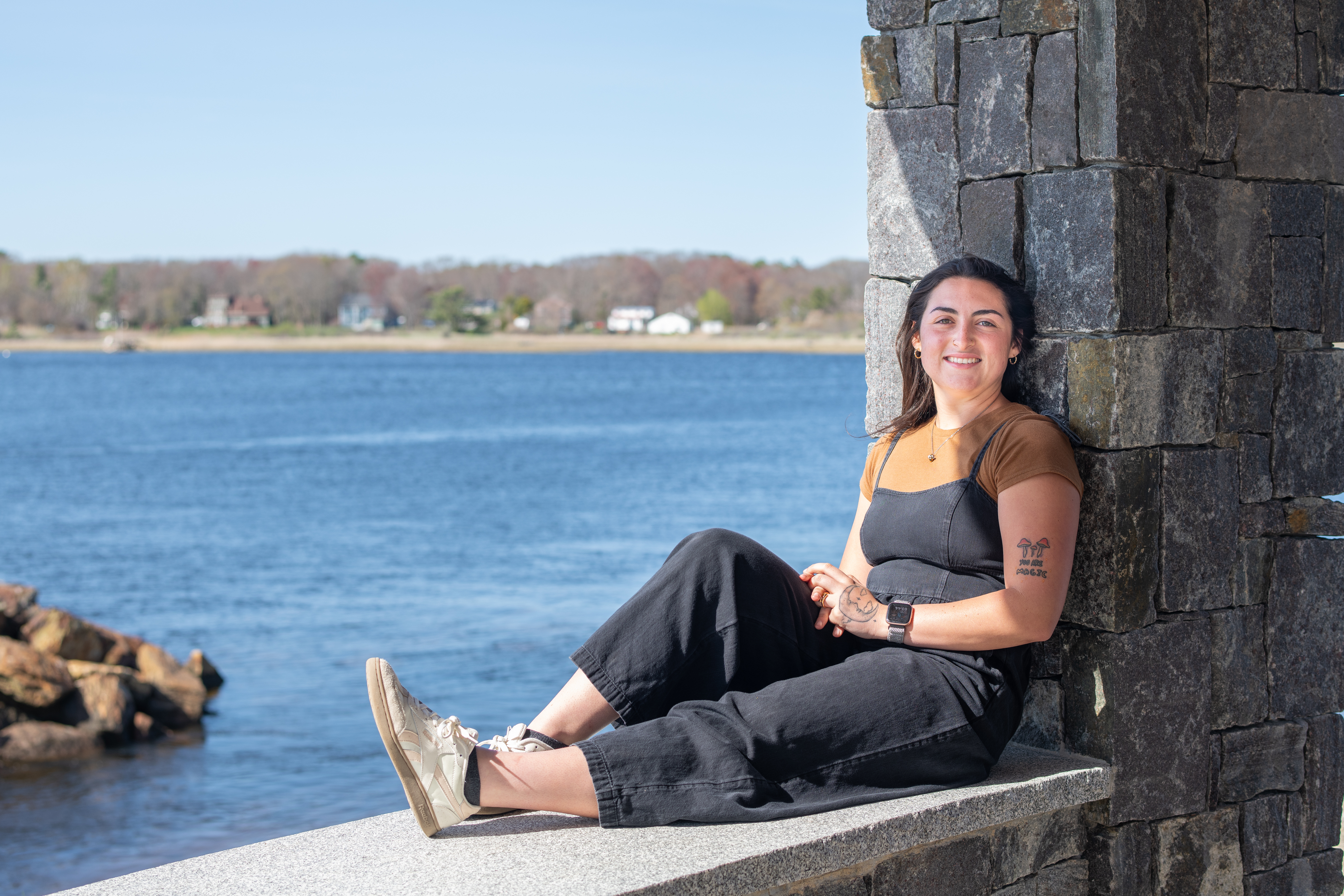 Morgan Bassett sits at Jordan's Point on UNE's campus