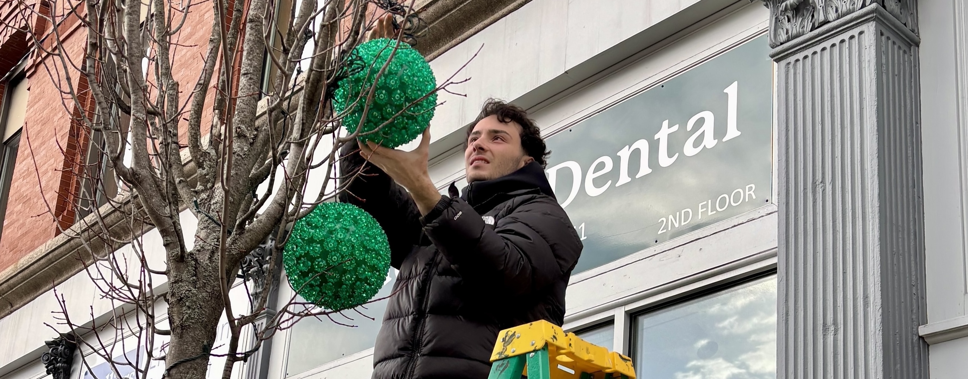 UNE students hang holiday lights, help provide holiday cheer in downtown Biddeford 