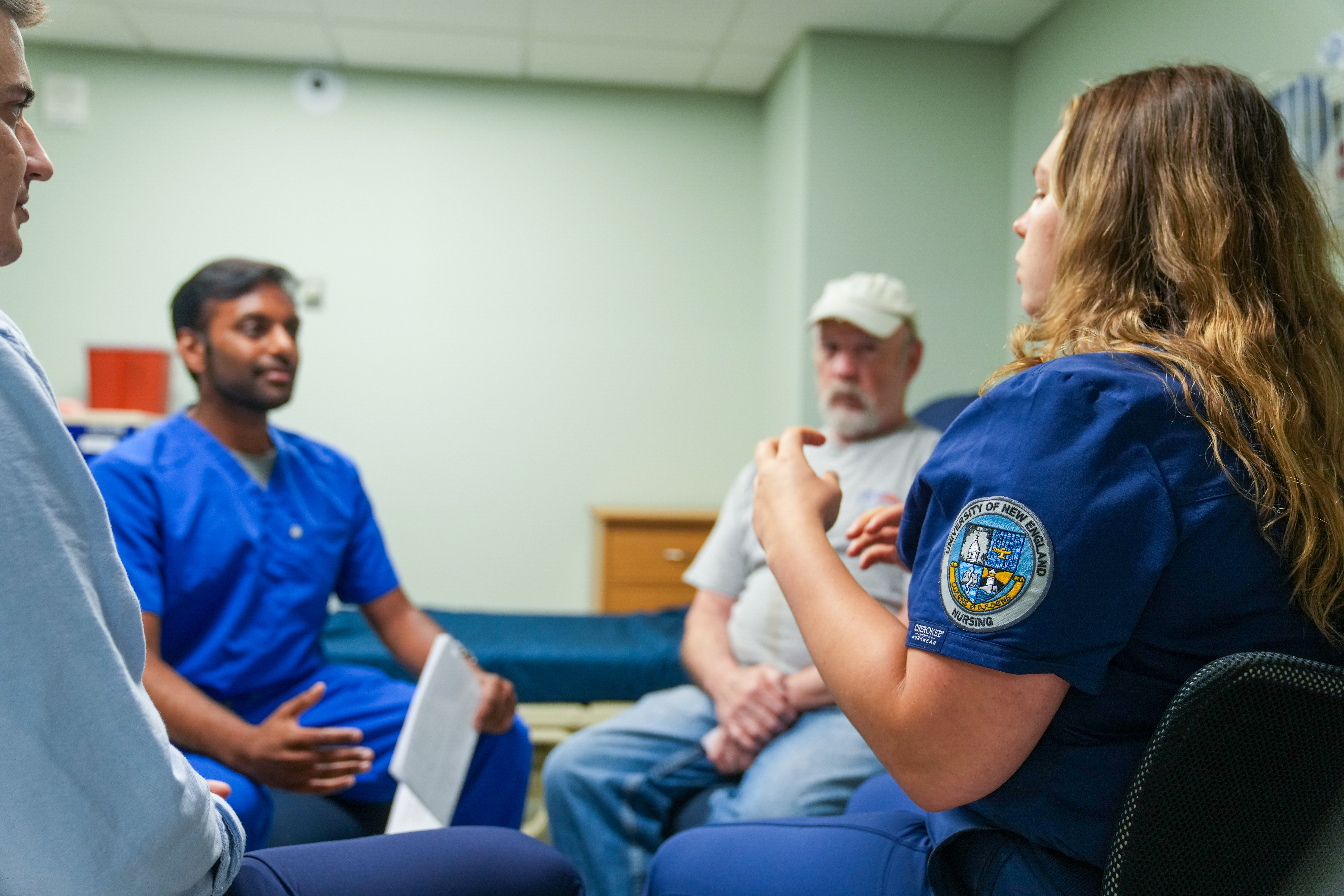 Health care students discuss care options in UNE's simulation lab