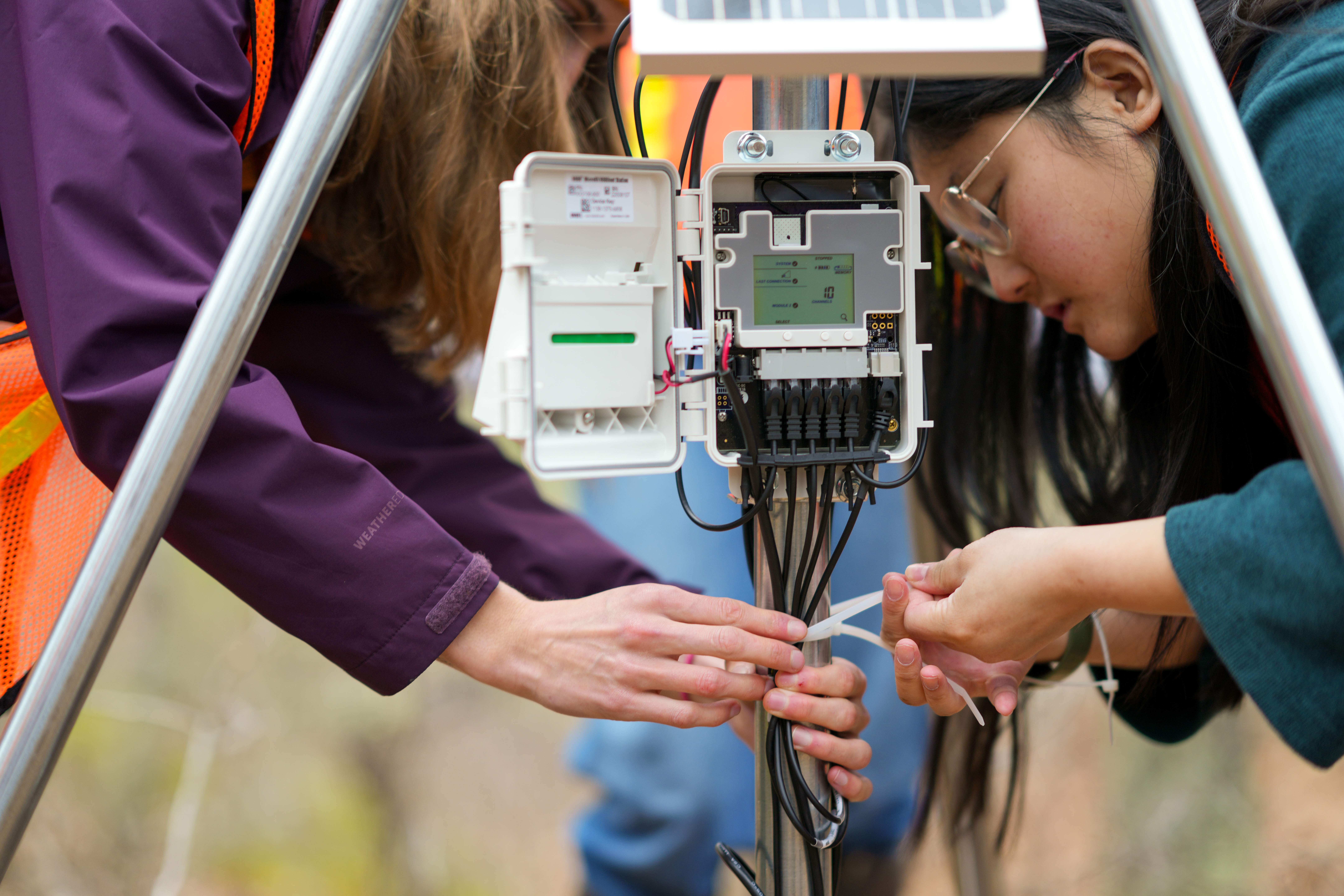 Students tie off a weather monitoring system 