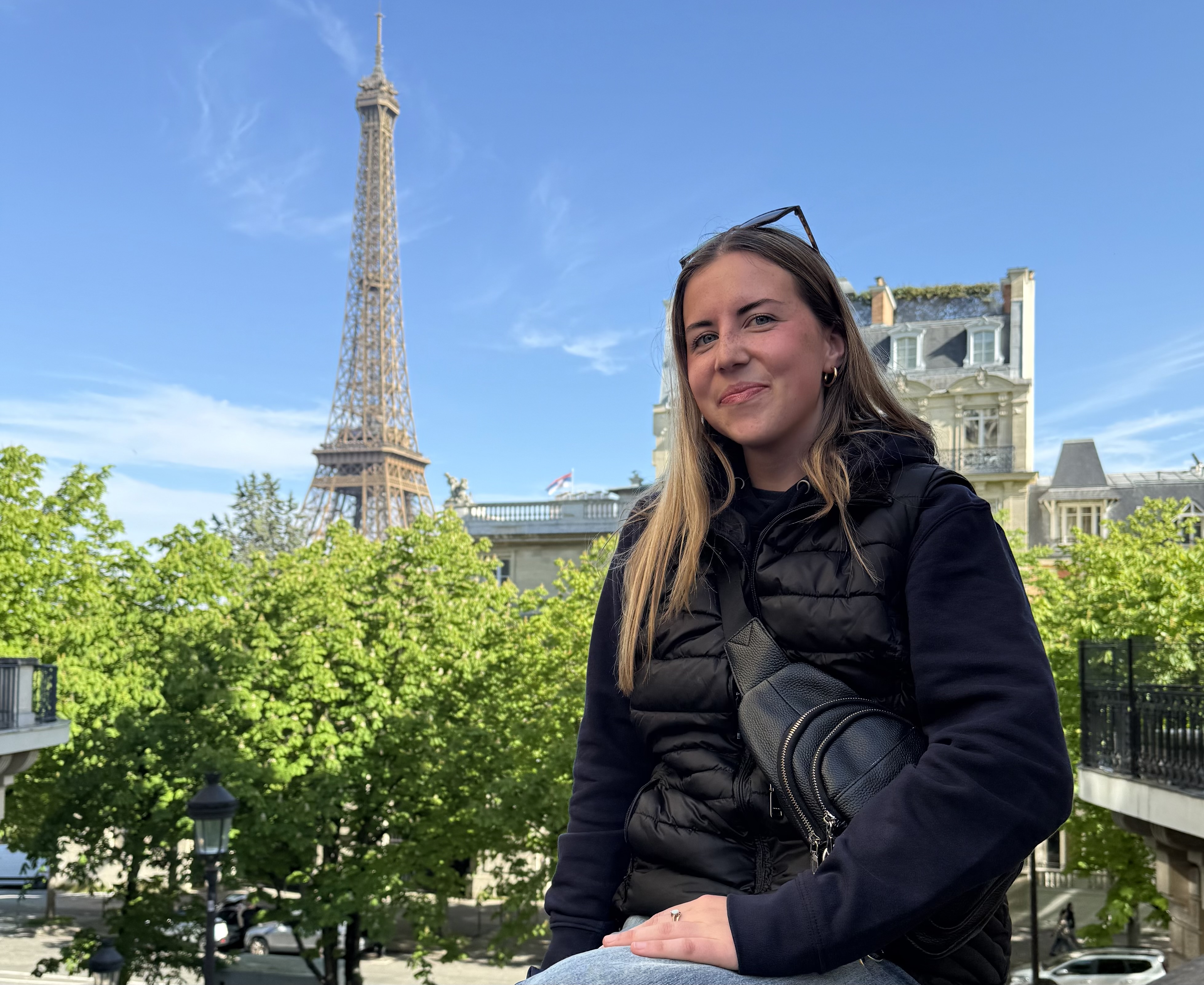 UNE student Cally Gudroe poses in Paris with the Eiffel Tower in the background