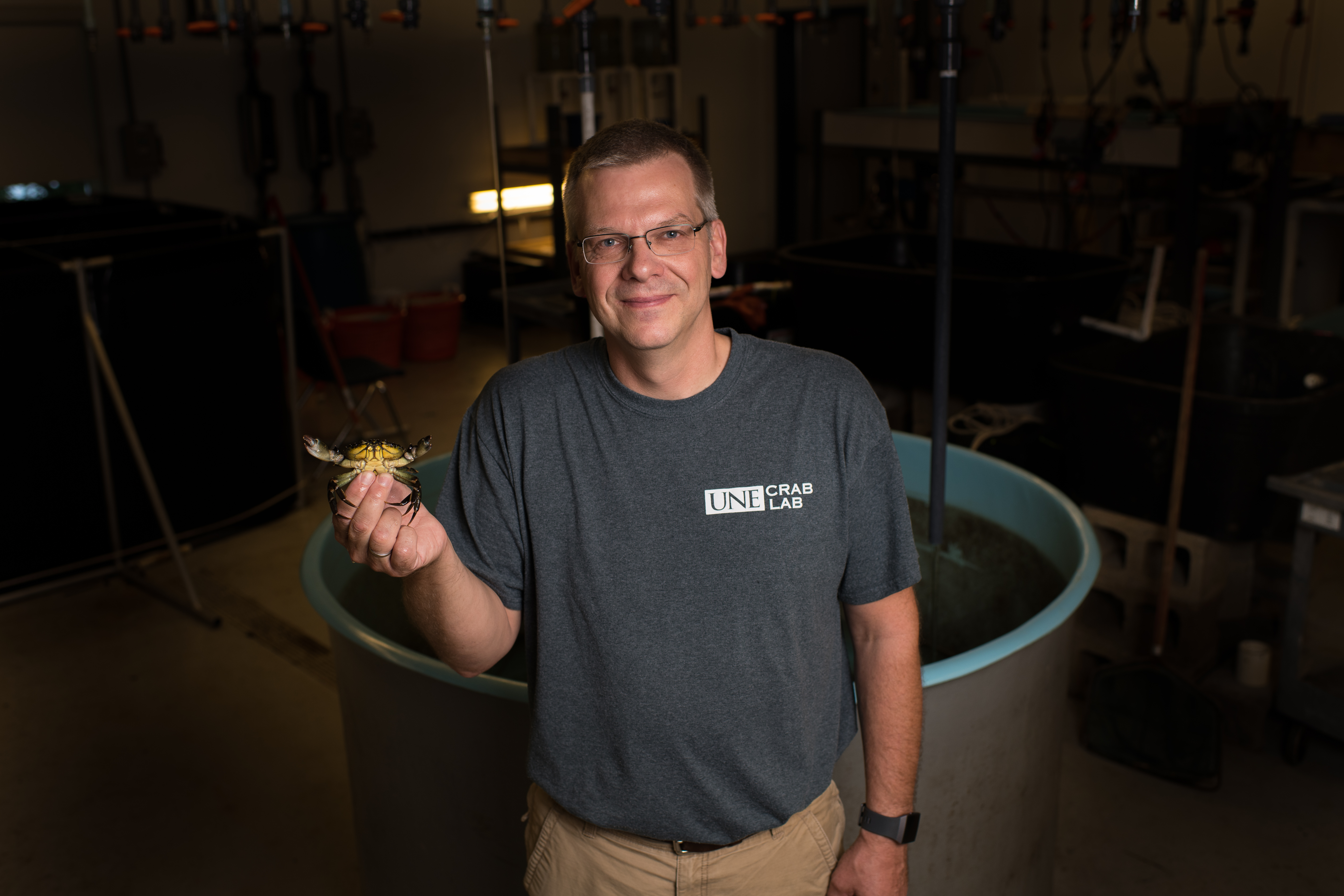 Frederich holding a crab in front of a salt water tank