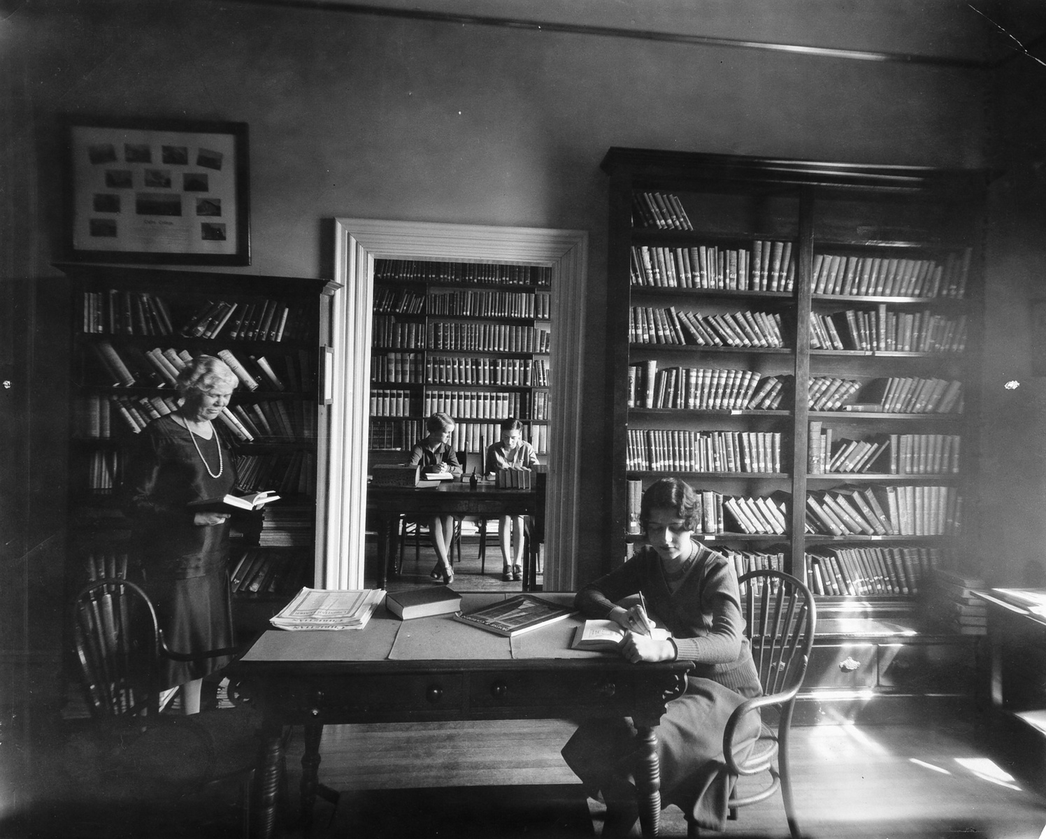 Black and white historic photograph of women studying in a library 
