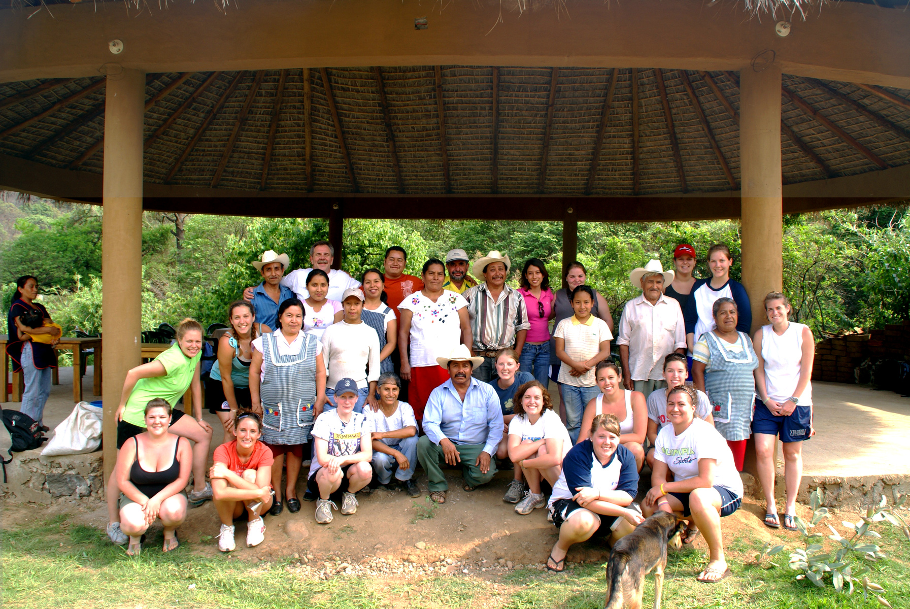 U N E students pose with native Mexicans below a straw thatch picnic shelter