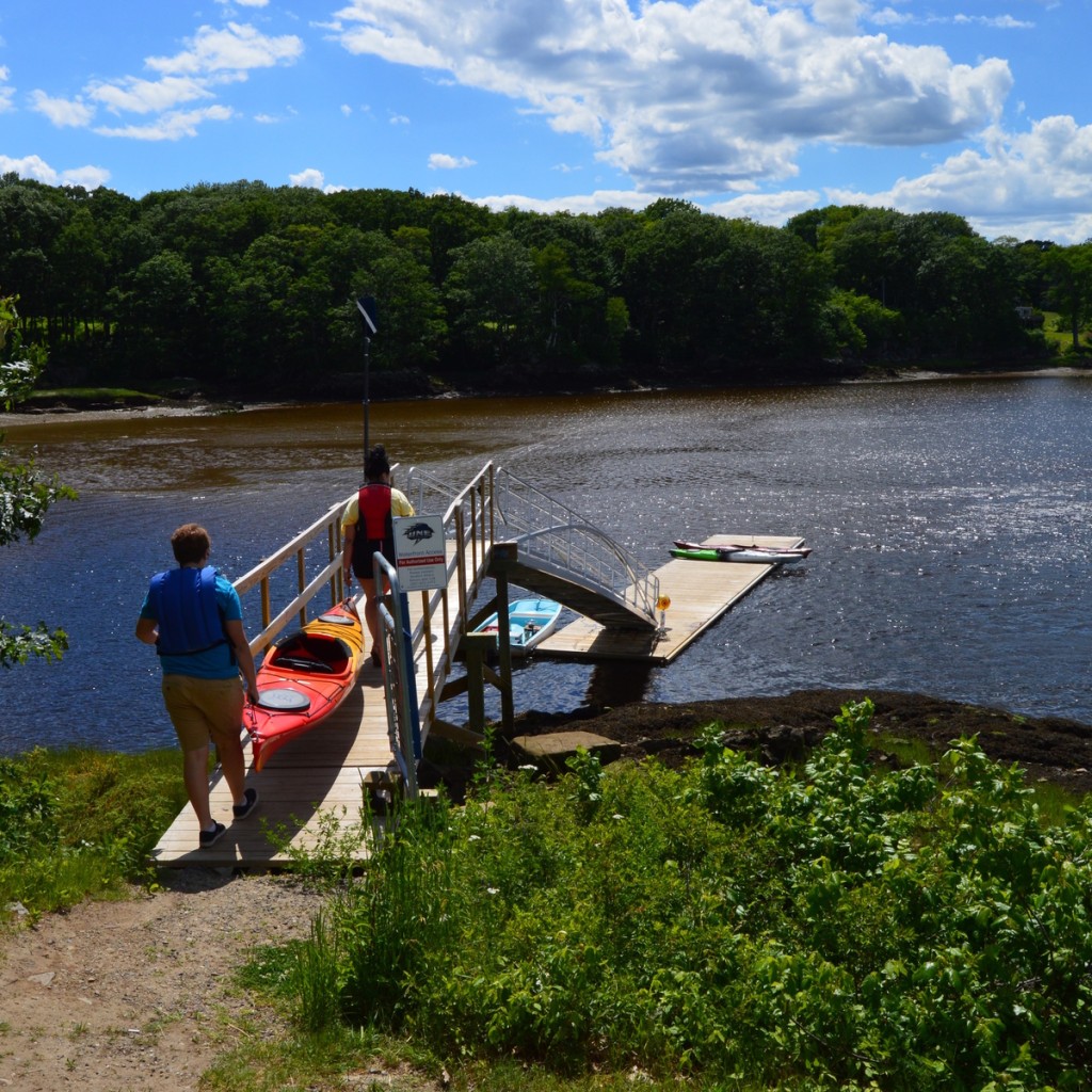 students launch kayaks from a dock