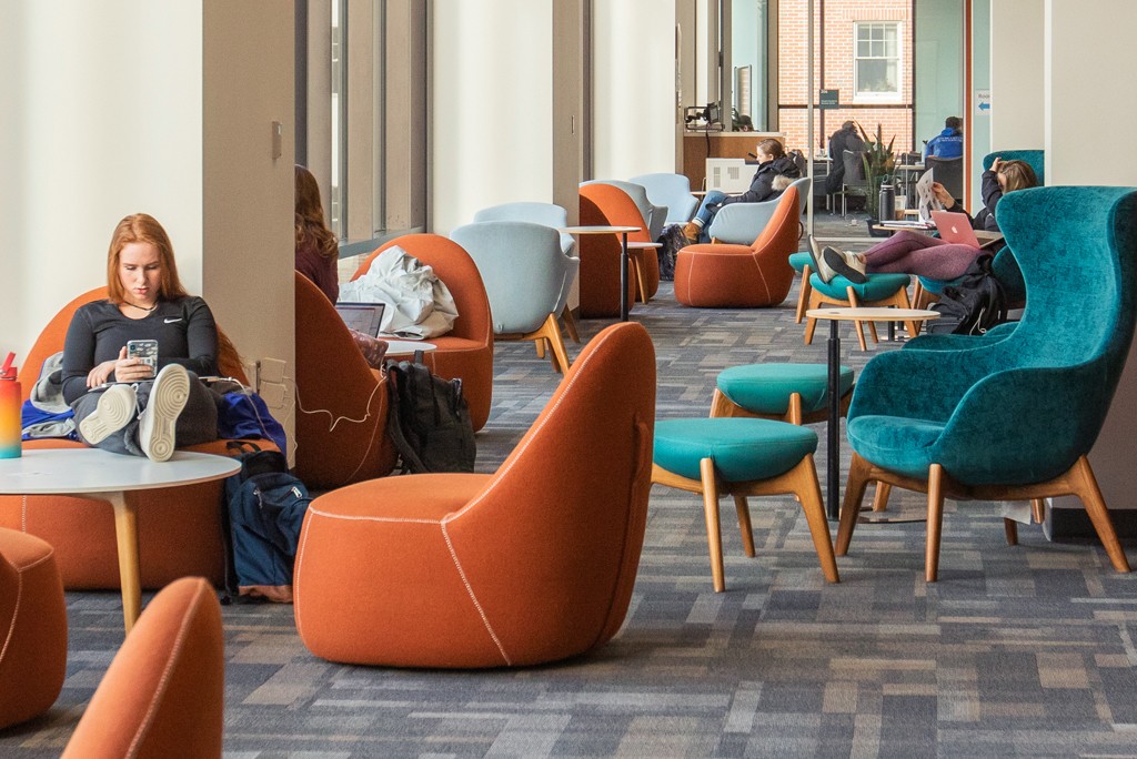  students relax in comfy chairs on the second floor of the Ripich Commons