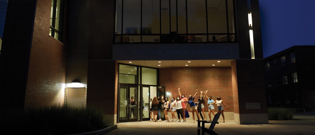 Students outside the Commons at night