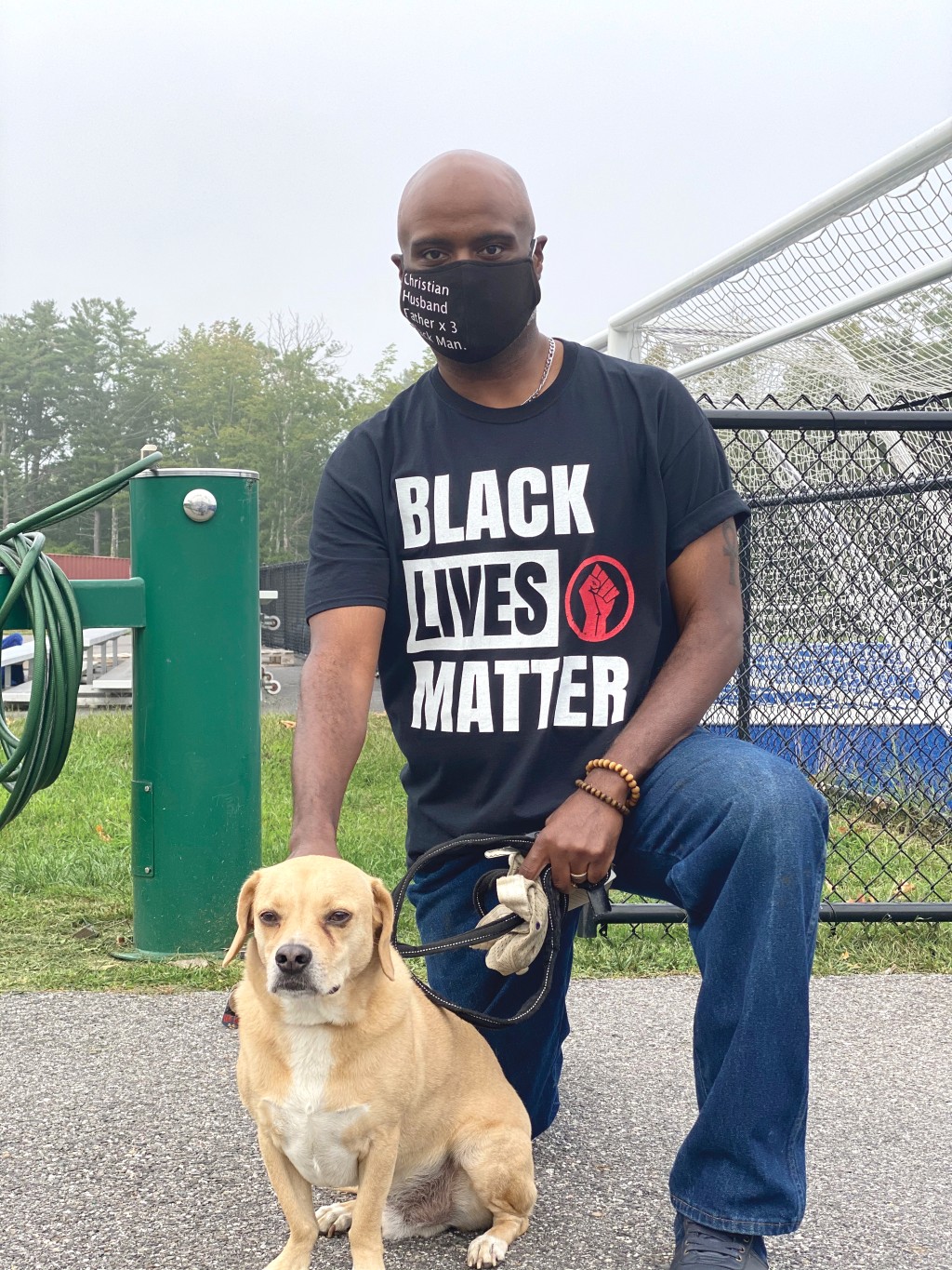 chris hunt wearing a black lives matter t-shirt poses with his dog
