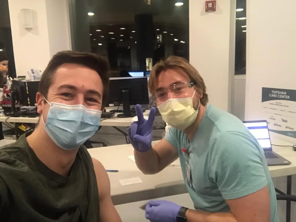 Drew Smith-Freedman (D.O. ’22), right, vaccinates his younger brother, first-year UNE COM student Duncan Smith-Freedman.