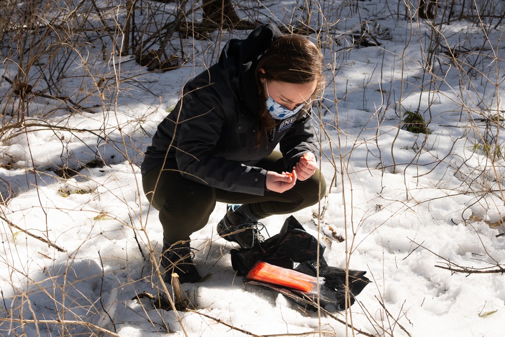 A U N E student preparing to collect data in an outdoor experiment 