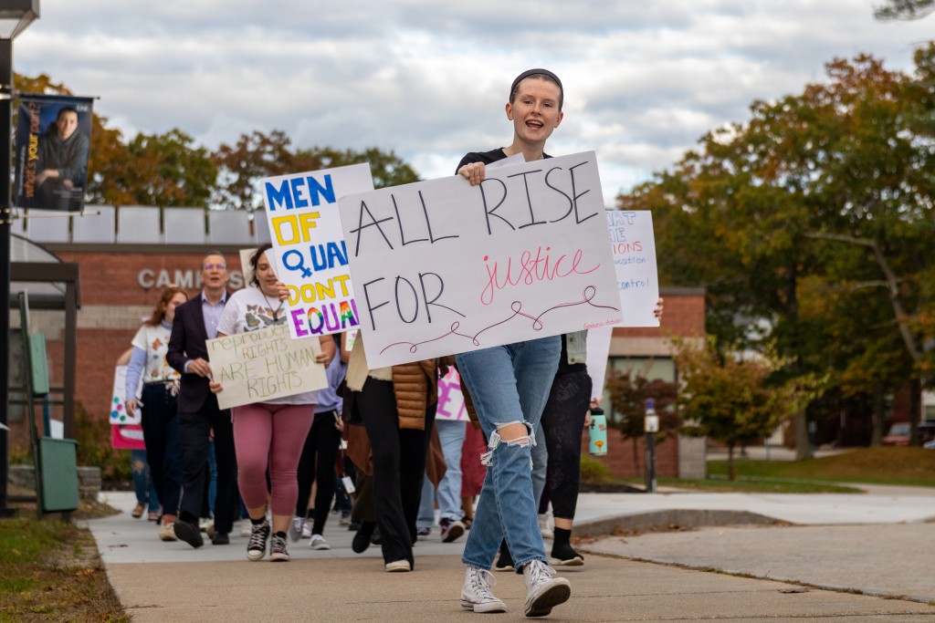 Students march with signs at UNE