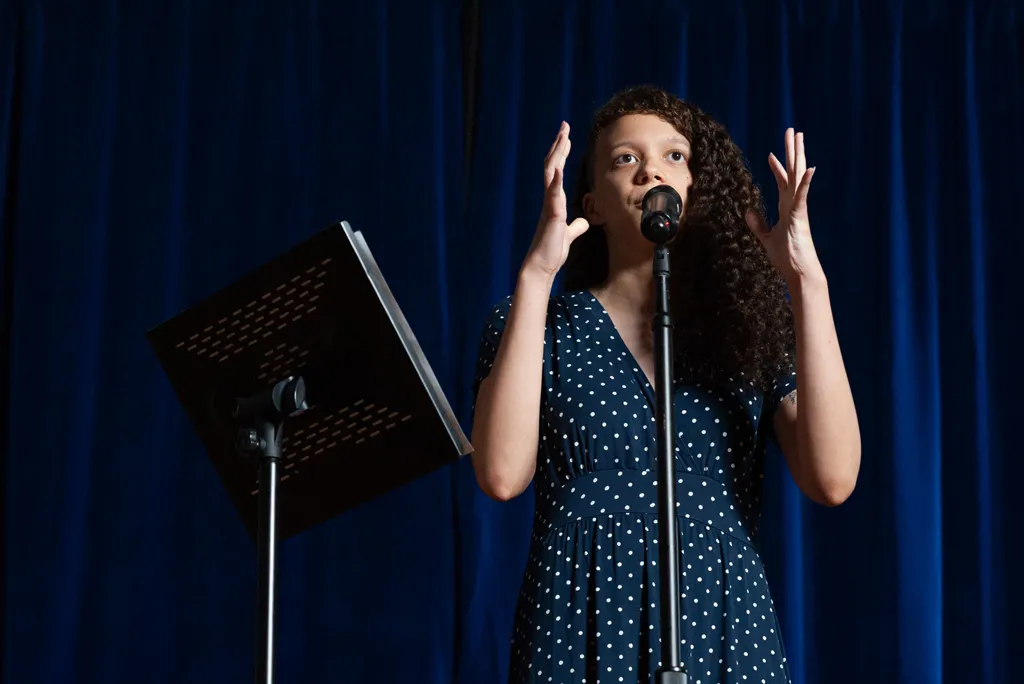 U N E alumnus reading poetry on stage