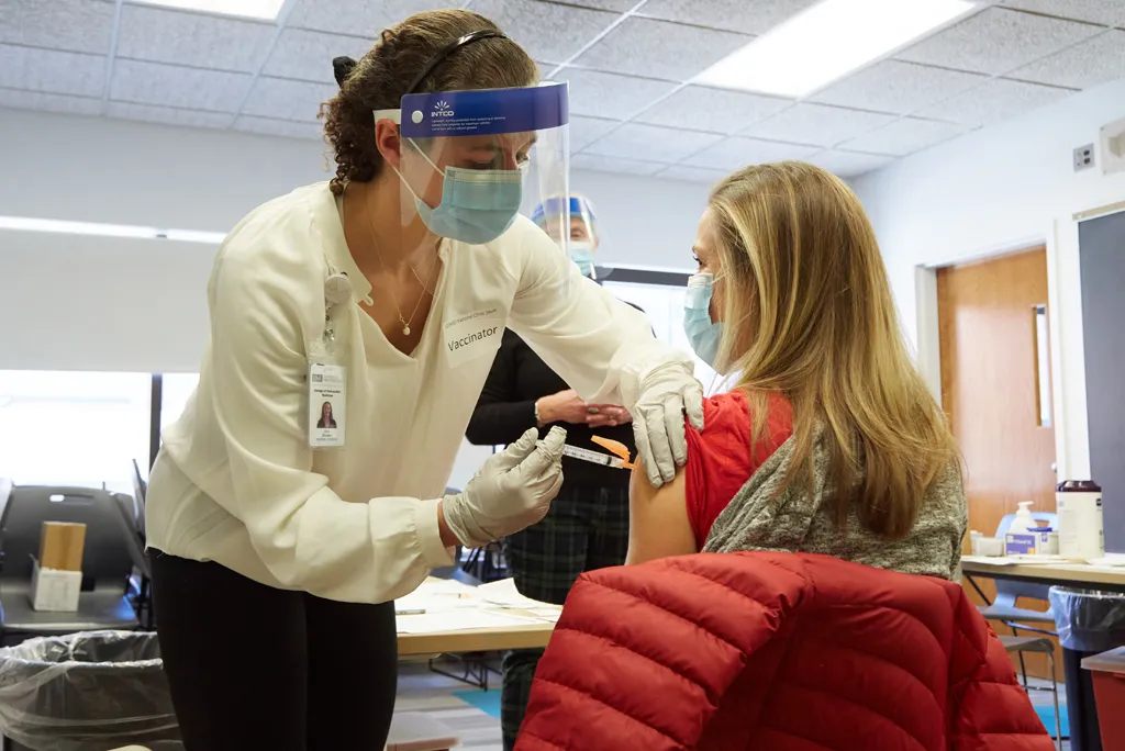 U N E student giving a vaccine