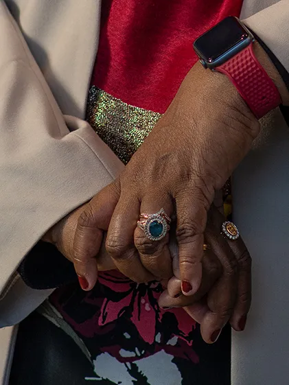 Deqa Dhalac's hands are pictured, crossed, with rings visible