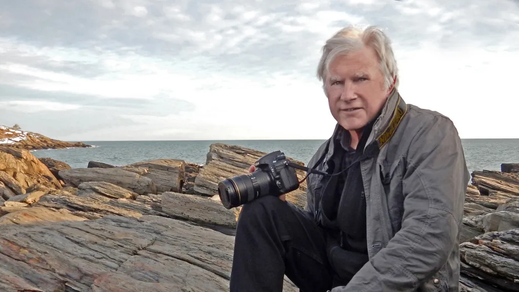 Photo of David Evans Shaw against rocks and the ocean