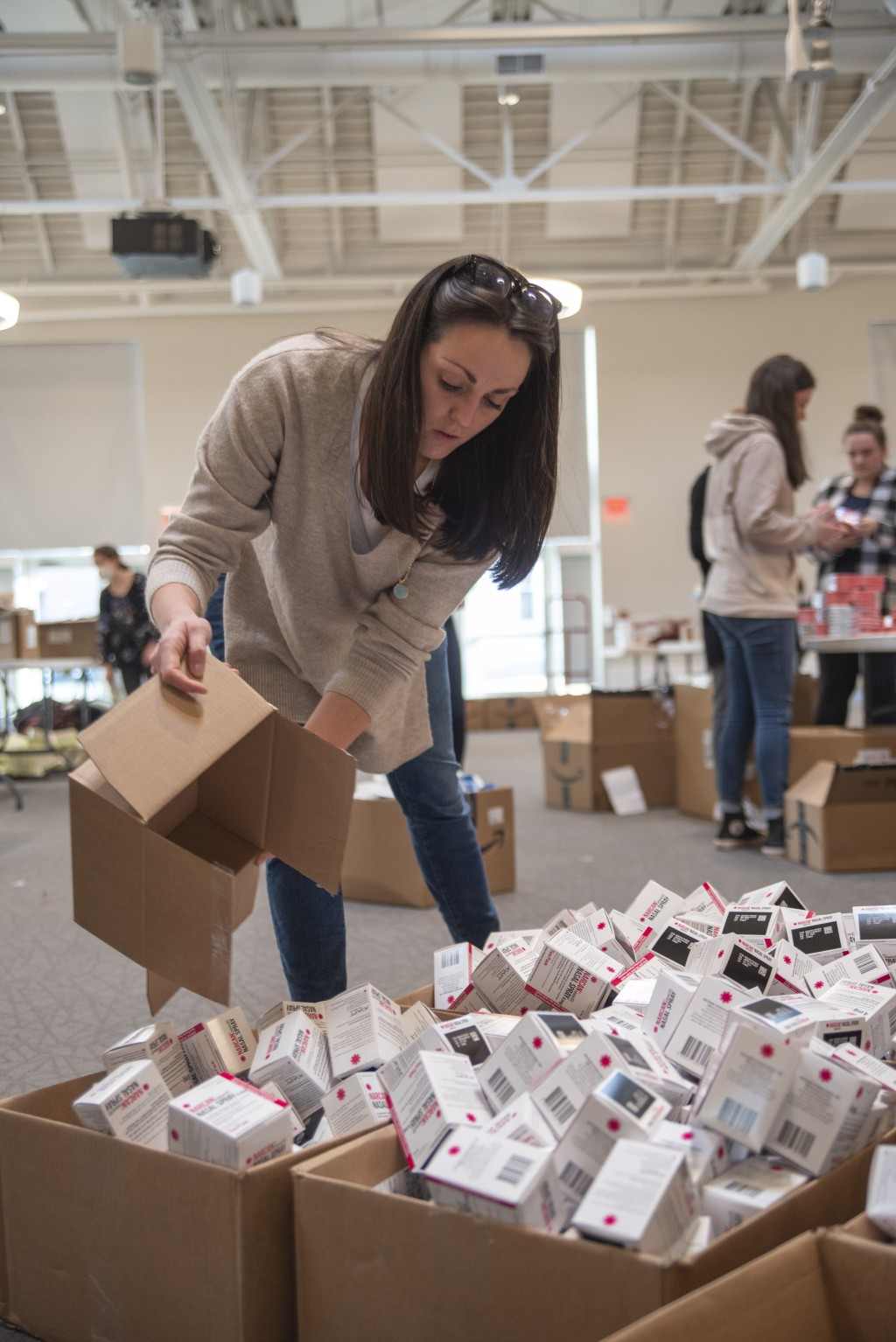 A female student prepares a box of Narcan for distribution into the kits