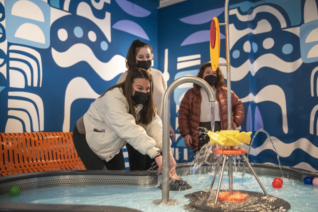 Students play with water at an exhibit at the children's museum