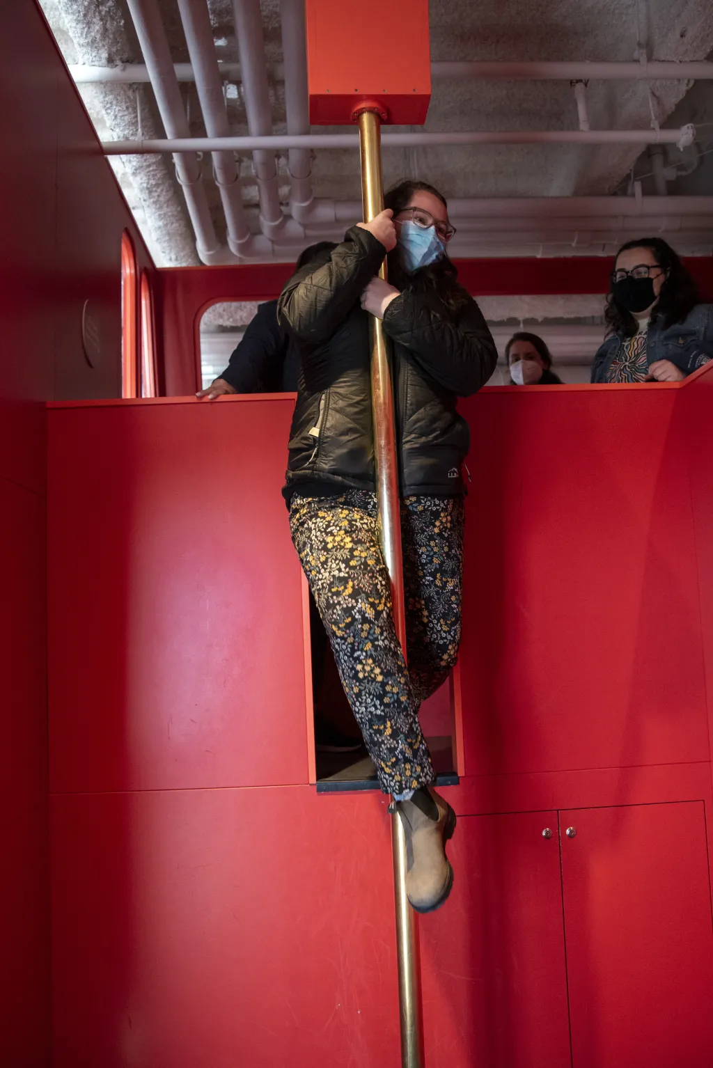 A student slides down the firefighter's pole at a life-size replica of a fire truck