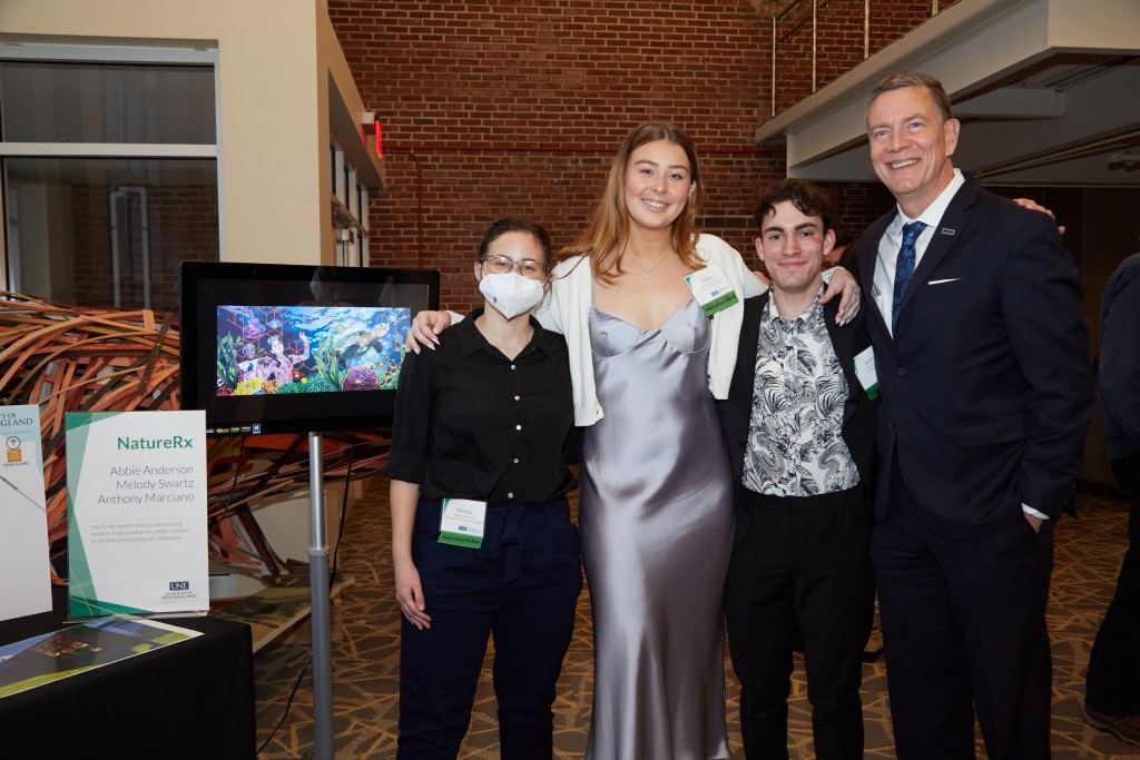 UNE President James Herbert poses with a student group at the Innovation Showcase