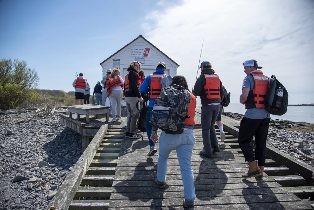 Students gather at the dock on Wood Island as they embark on a lesson plan to play 'Survivor'