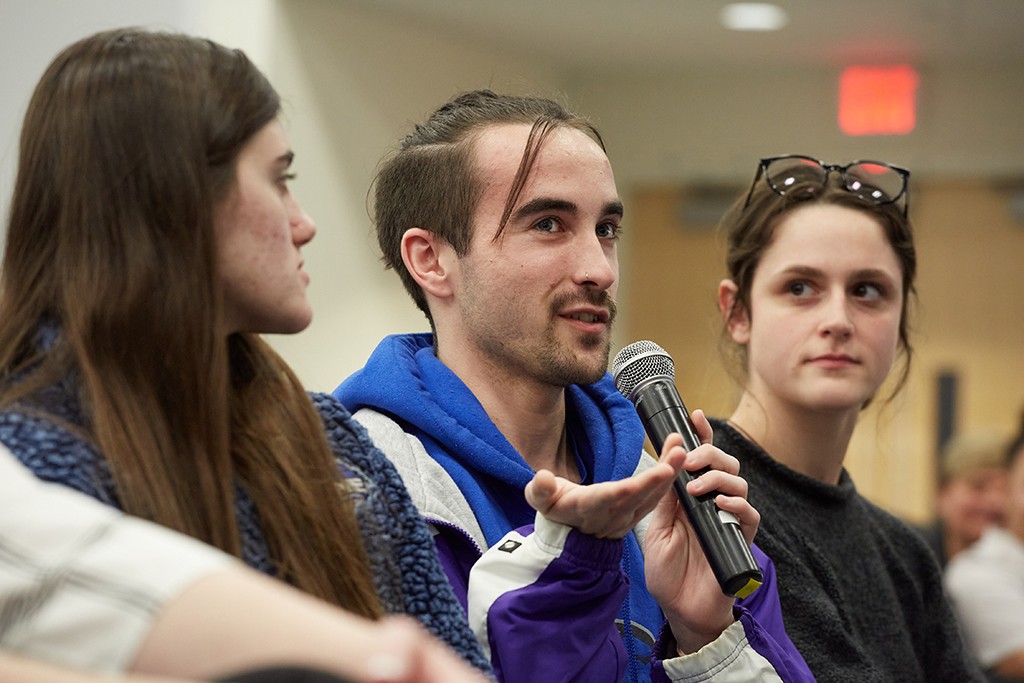 A student in a crowd asks the lecturer a question at an event