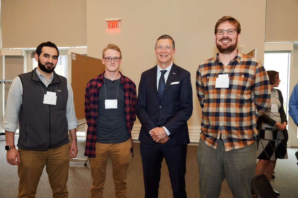 President Herbert poses with UNE researcher Ben Harrison and students